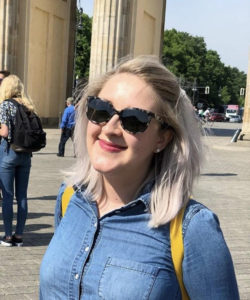 Photo of Mary Worrell smiling at the Brandenburg Gate in Berlin, Germany